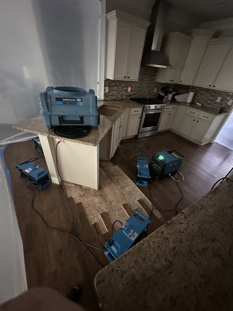 Before: Drying equipment set on a wet hardwood kitchen floor