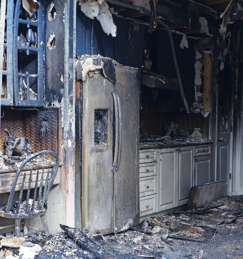 The charred interior of a fire damaged kitchen before repairs
