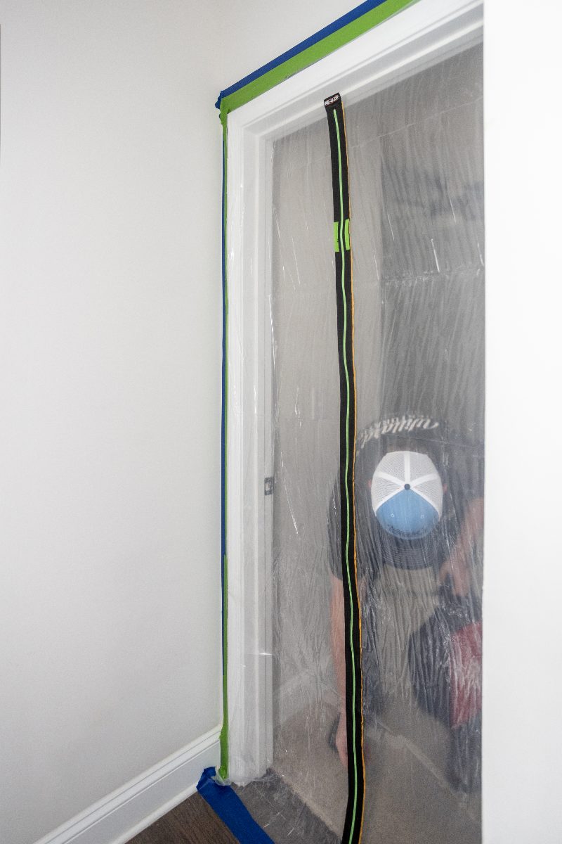 A containment barrier sealed over a doorway before lead paint work begins