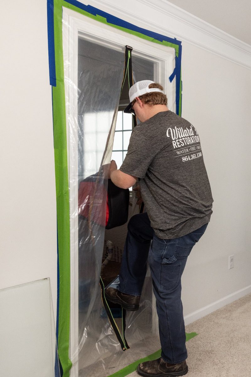 A technician stepping through a containment barrier